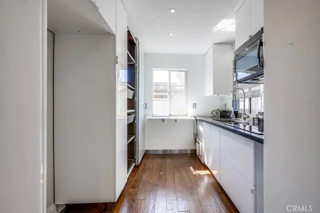 a kitchen with cabinets and wooden floor