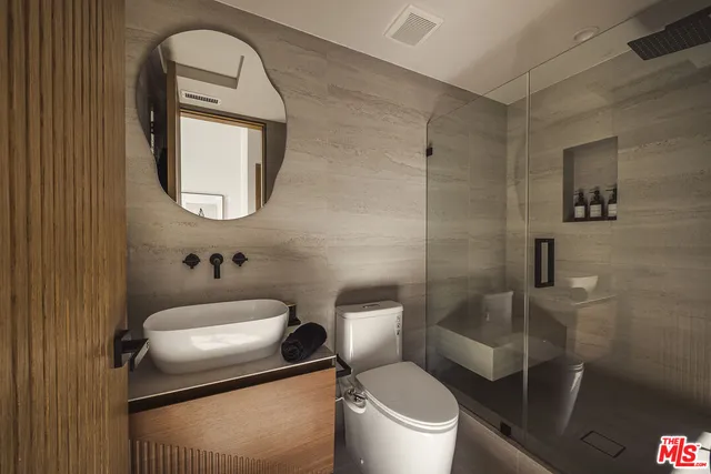 a bathroom with a toilet sink vanity and mirror