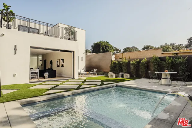 a view of a house with swimming pool and sitting area