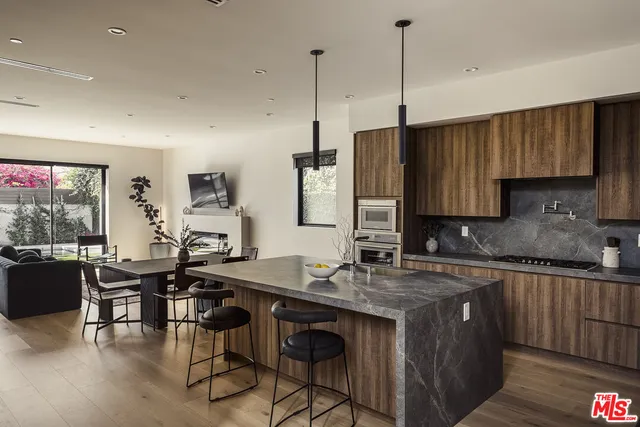 a kitchen with a sink a stove a dining table and chairs