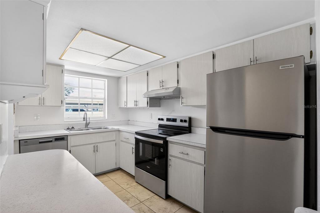 2560 Golf Course Drive, Unit 507 Sarasota, FL 34234 - Photo 12 of 43 a kitchen with stainless steel appliances a refrigerator sink and cabinets