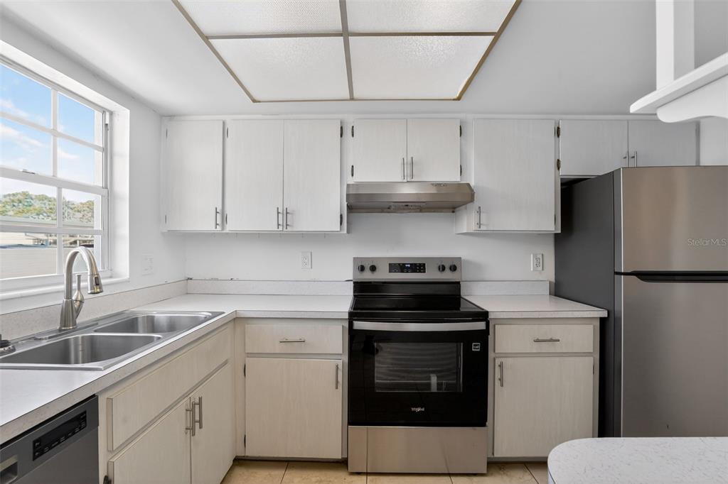 2560 Golf Course Drive, Unit 507 Sarasota, FL 34234 - Photo 13 of 43 a kitchen with stainless steel appliances a stove a sink and a refrigerator