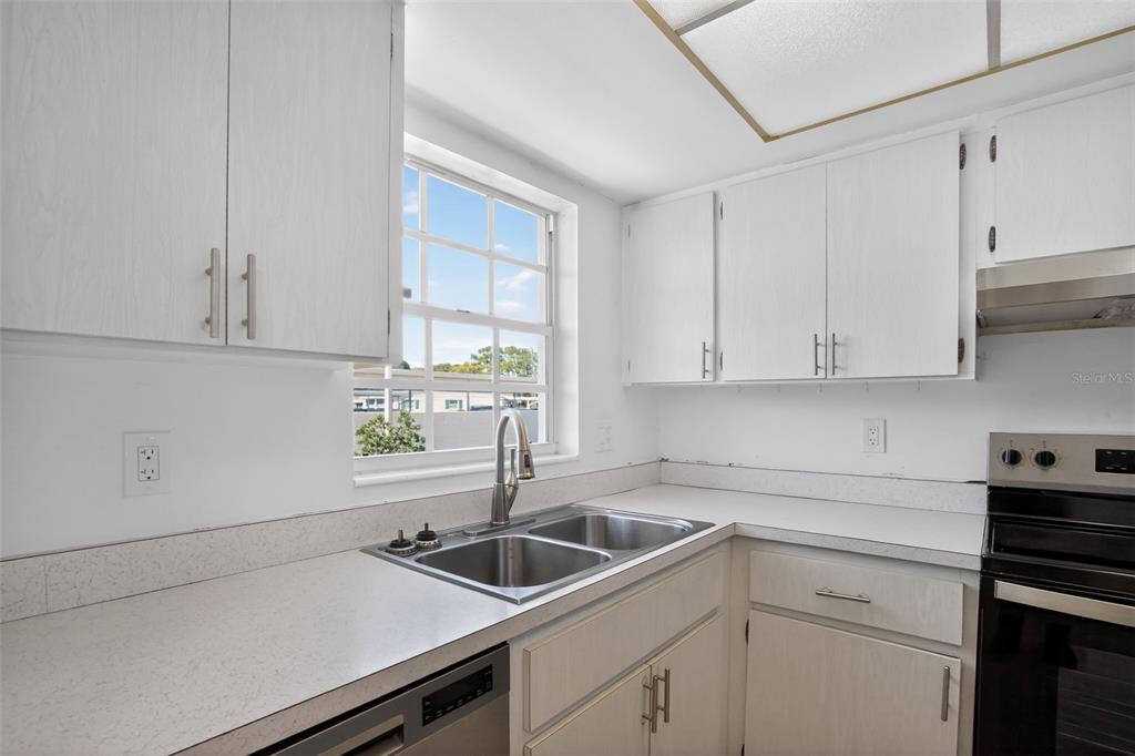 2560 Golf Course Drive, Unit 507 Sarasota, FL 34234 - Photo 14 of 43 a kitchen with a sink cabinets and window
