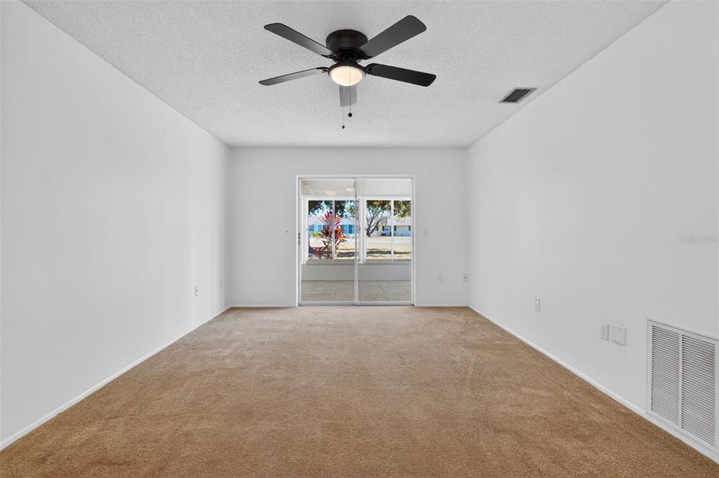 2560 Golf Course Drive, Unit 507 Sarasota, FL 34234 - Photo 21 of 43 an empty room with windows and a ceiling fan