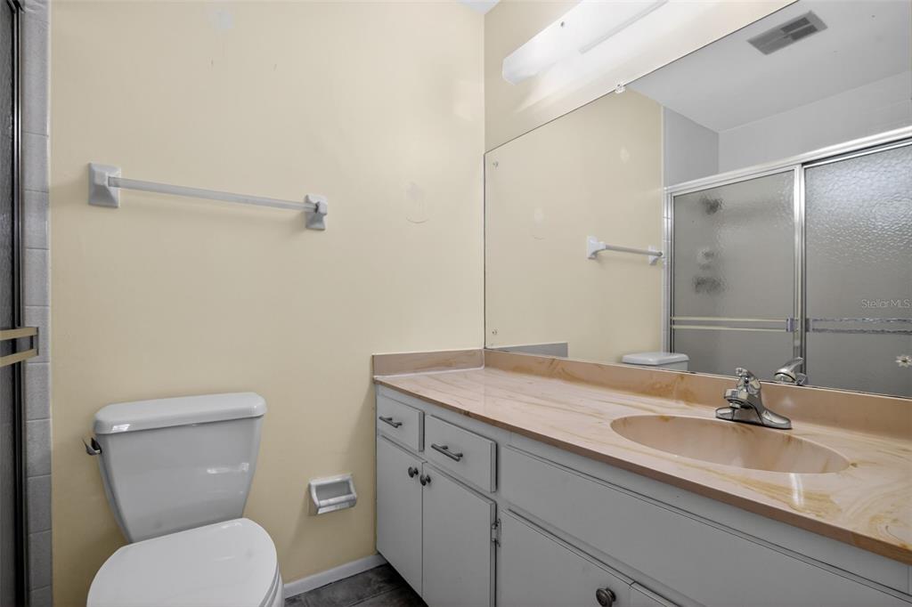 2560 Golf Course Drive, Unit 507 Sarasota, FL 34234 - Photo 27 of 43 a bathroom with a granite countertop toilet sink and mirror