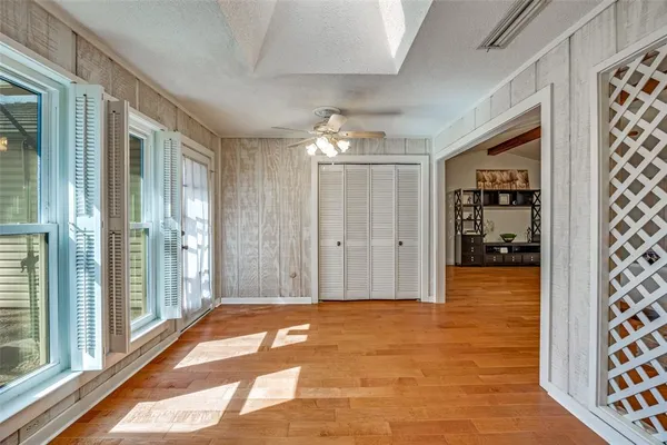 a view of a hallway with wooden floor and a dining room