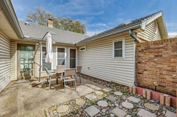 a backyard of a house with table and chairs