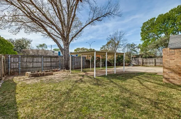 a view of a yard with wooden fence and trees
