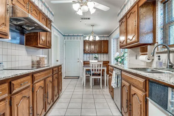 a kitchen with granite countertop lots of counter top space a sink stainless steel appliances and cabinets