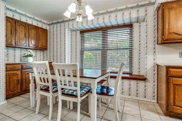 a white kitchen with a sink and chandelier