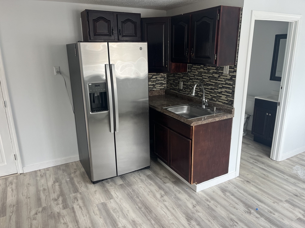 58 Brunswick Street Lowell, MA 01852 - Photo 13 of 33 a kitchen with granite countertop a refrigerator and a stove