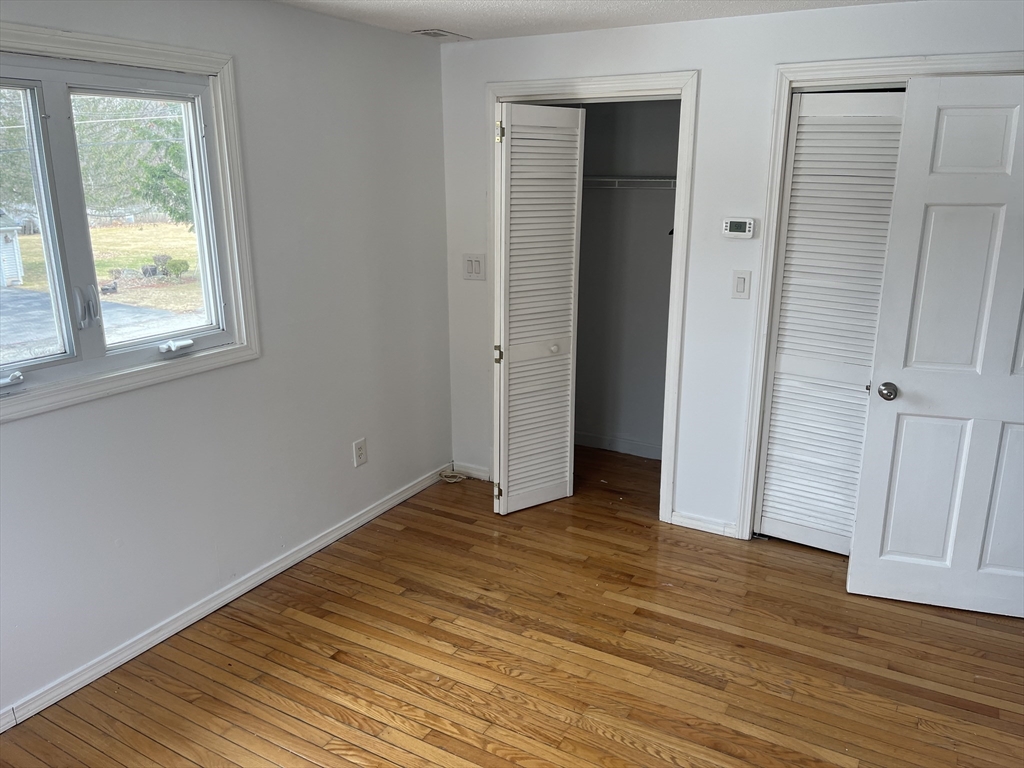 58 Brunswick Street Lowell, MA 01852 - Photo 15 of 33 a view of an empty room with wooden floor and a window