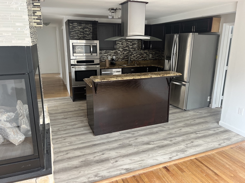 58 Brunswick Street Lowell, MA 01852 - Photo 4 of 33 a kitchen with stainless steel appliances granite countertop a refrigerator and a sink