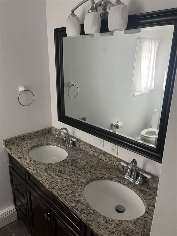 58 Brunswick Street Lowell, MA 01852 - Photo 7 of 33 a bathroom with a granite countertop sink and a mirror