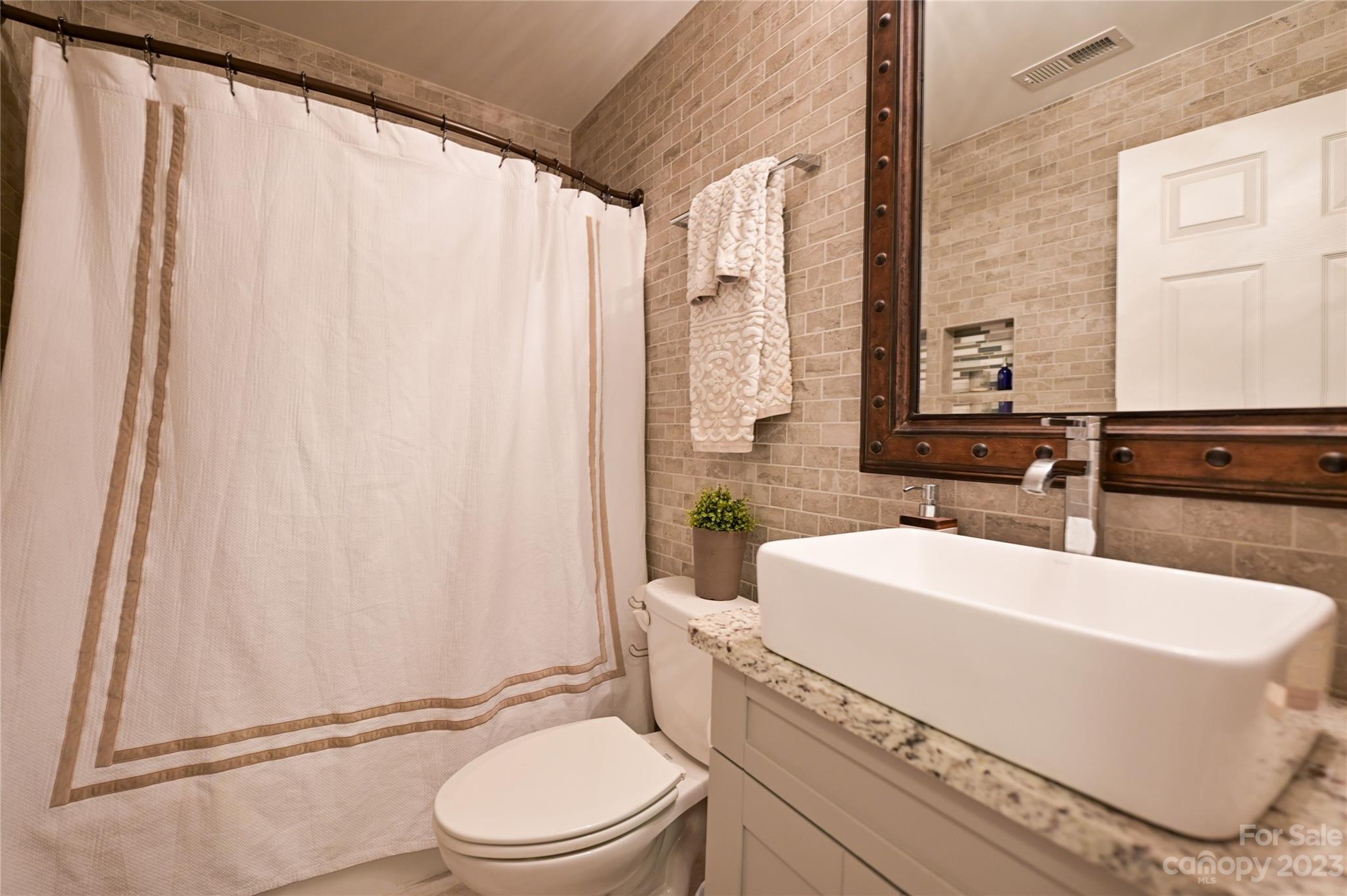 20109 Henderson Road, Unit D Cornelius, NC 28031 - Photo 16 of 18 a bathroom with a sink toilet and shower
