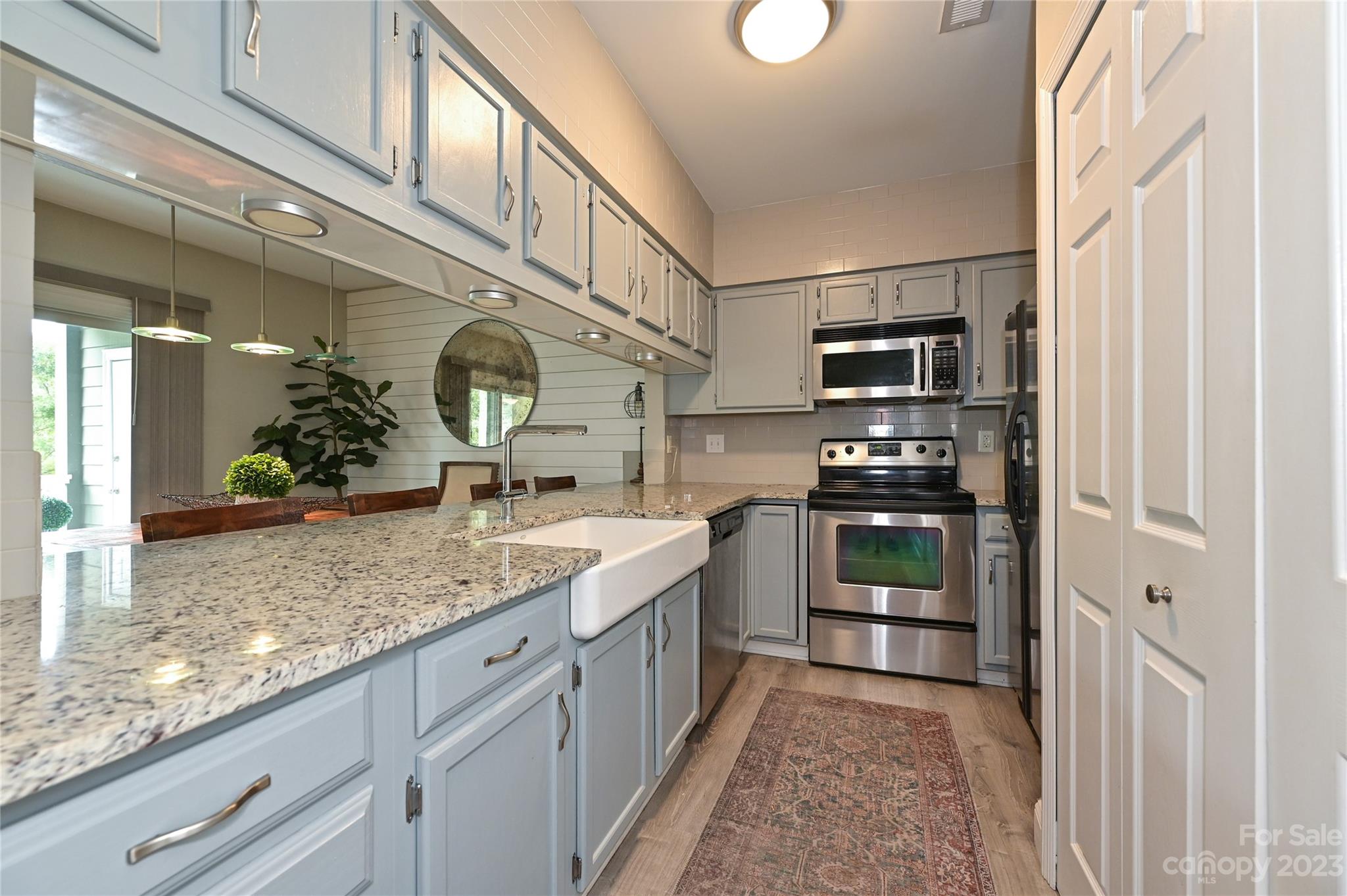 20109 Henderson Road, Unit D Cornelius, NC 28031 - Photo 4 of 18 a kitchen with stainless steel appliances granite countertop a sink and a refrigerator