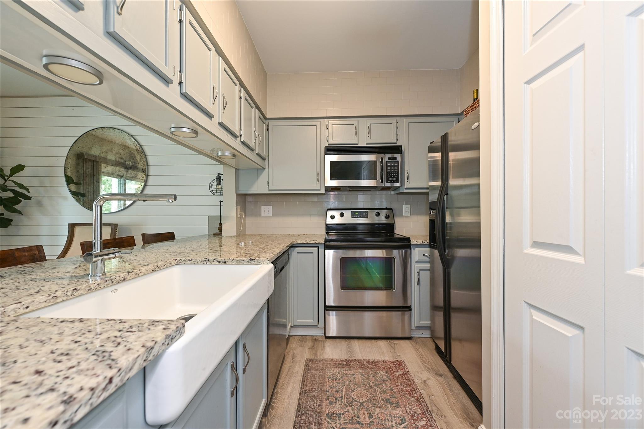 20109 Henderson Road, Unit D Cornelius, NC 28031 - Photo 5 of 18 a kitchen with stainless steel appliances granite countertop a sink and a stove