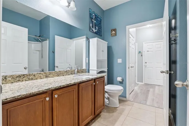 a bathroom with a granite countertop sink toilet and shower
