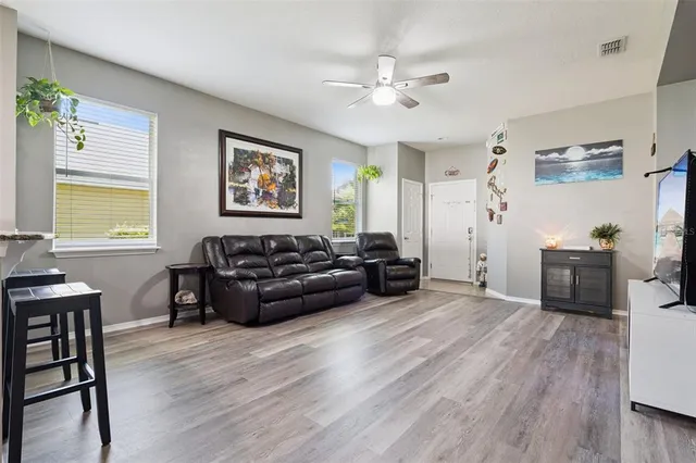 a living room with furniture and a wooden floor