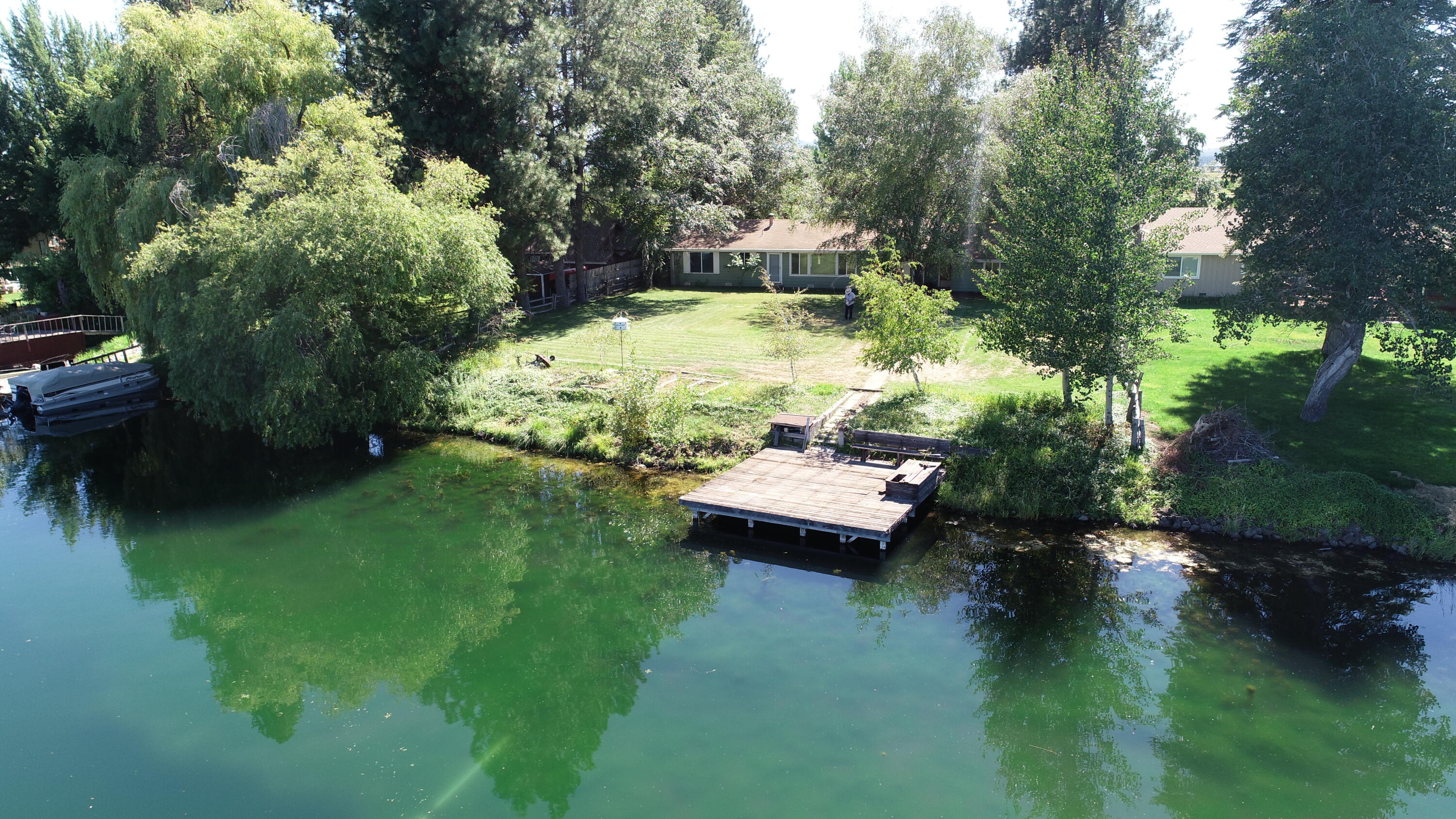 41916 Creighton Road Fall River Mills, CA 96028 - Photo 1 of 50 a view of a lake with lawn chairs and a yard