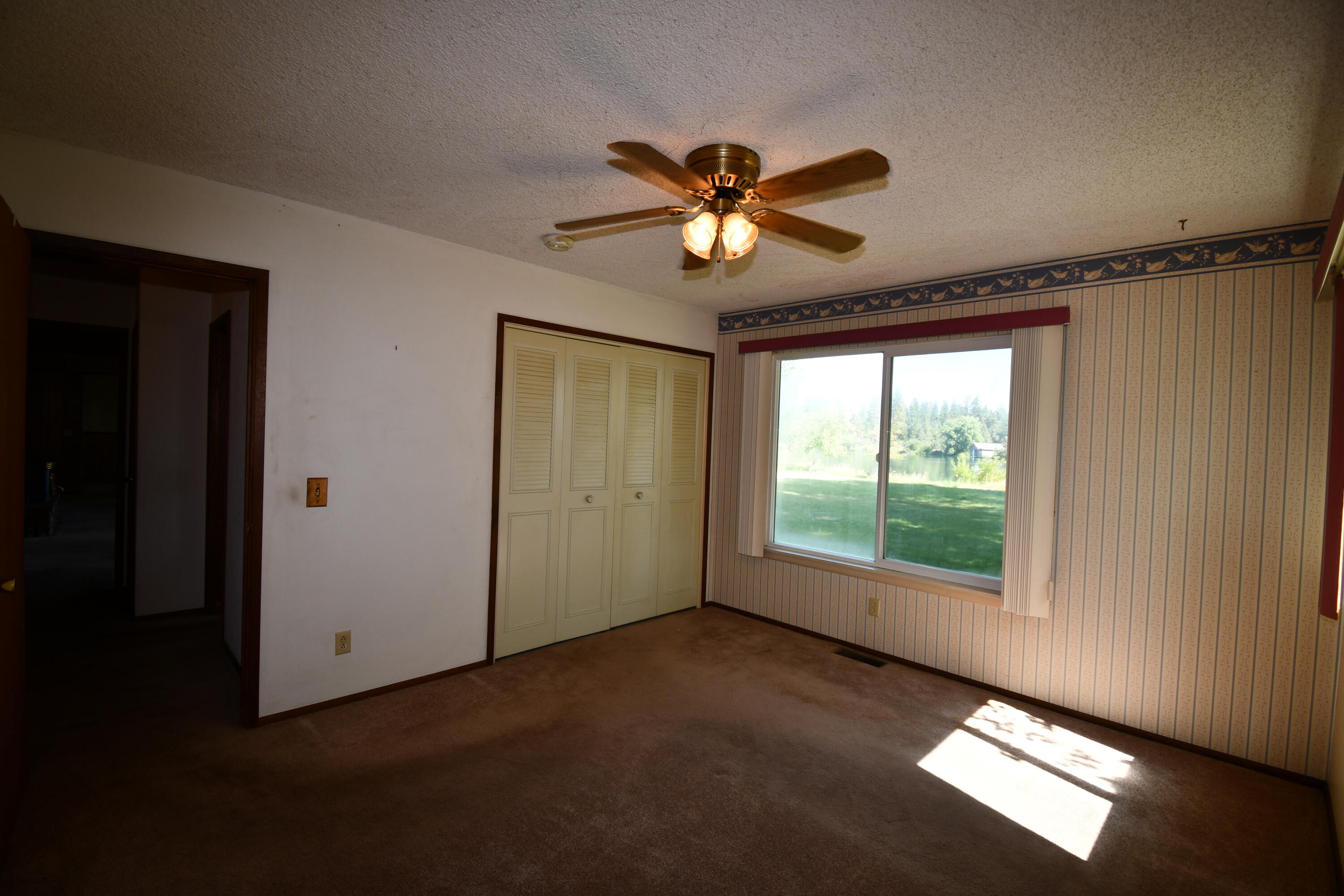 41916 Creighton Road Fall River Mills, CA 96028 - Photo 23 of 50 a view of an empty room with window and chandelier fan