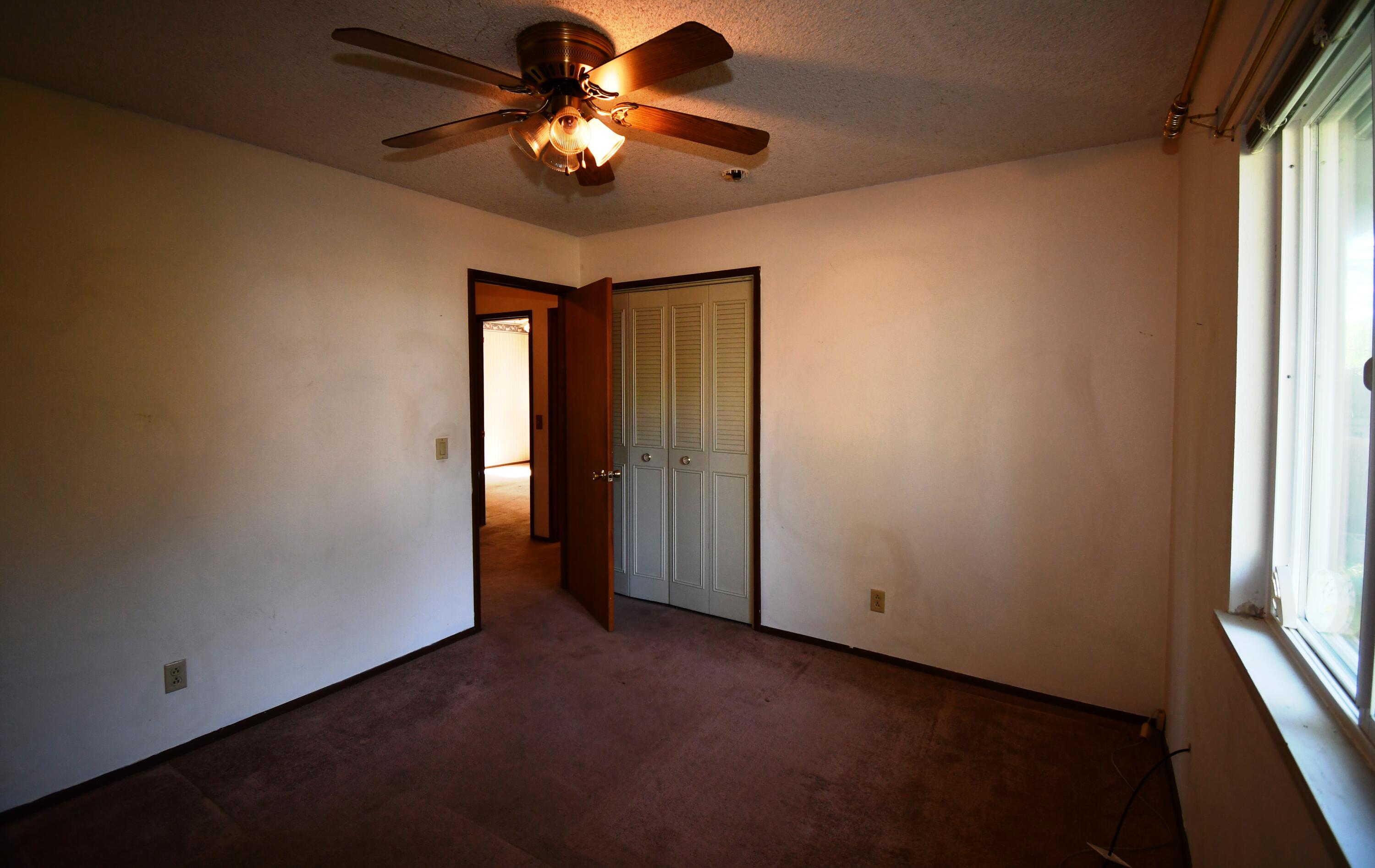 41916 Creighton Road Fall River Mills, CA 96028 - Photo 27 of 50 an empty room with chandelier fan and windows