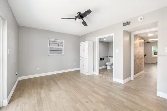 a view of empty room with wooden floor and window