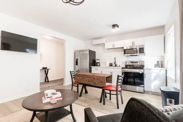 a living room with stainless steel appliances kitchen island granite countertop furniture and a fireplace