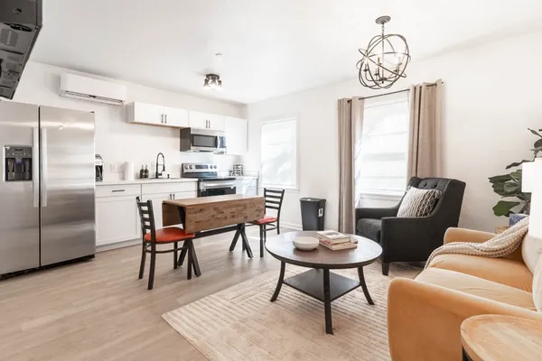 a kitchen with stainless steel appliances kitchen island granite countertop a dining table and chairs in it