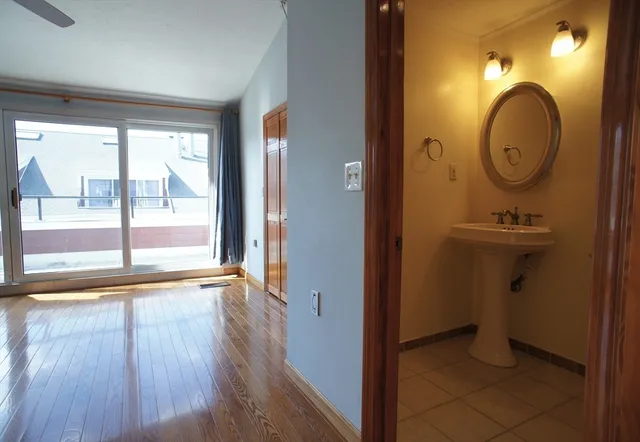 a view of a room with wooden floor mirror and window