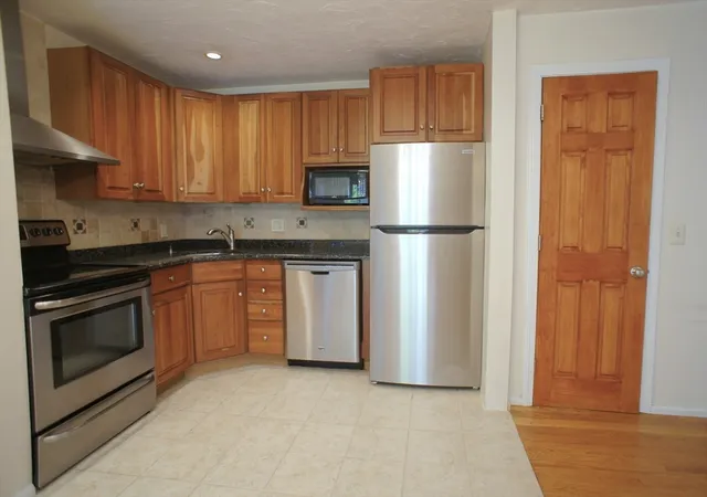 a kitchen with a refrigerator sink and cabinets