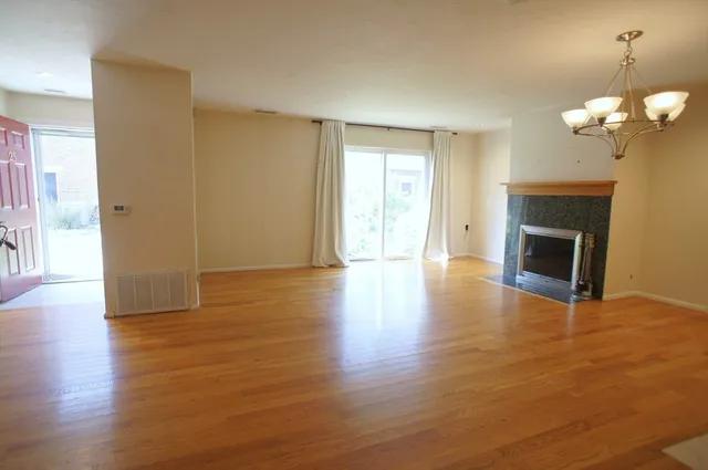 a view of a room with wooden floor and a fireplace