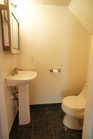 a bathroom with a sink toilet and mirror