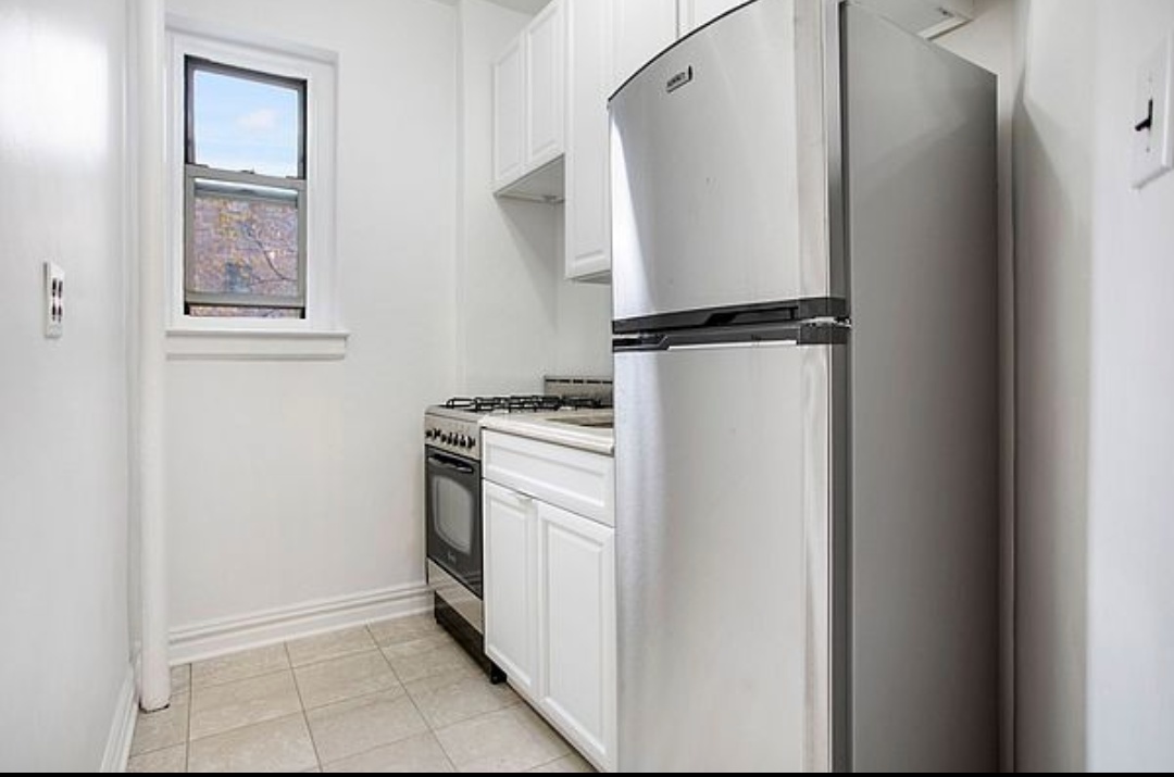 79-01 35th Avenue, Unit 4F Queens, NY 11372 - Photo 6 of 11 a utility room with cabinets washer and dryer