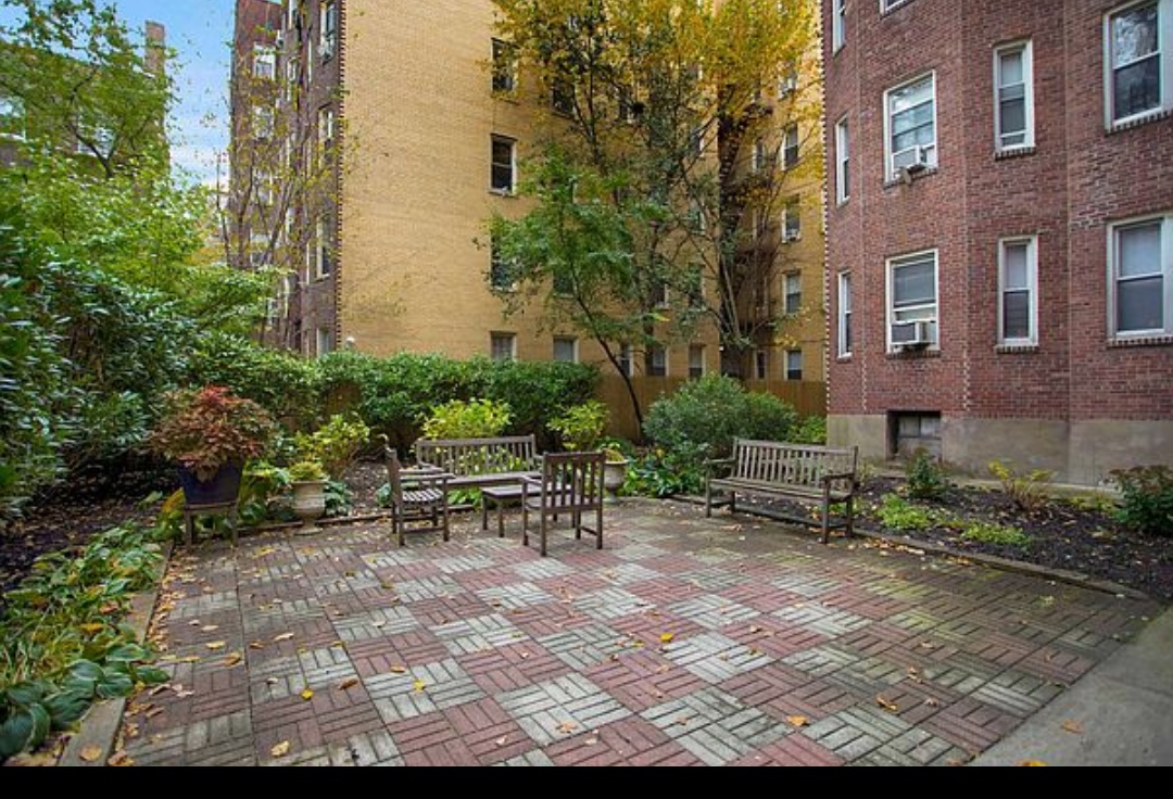 79-01 35th Avenue, Unit 4F Queens, NY 11372 - Photo 10 of 11 a view of backyard with table and chairs and potted plants