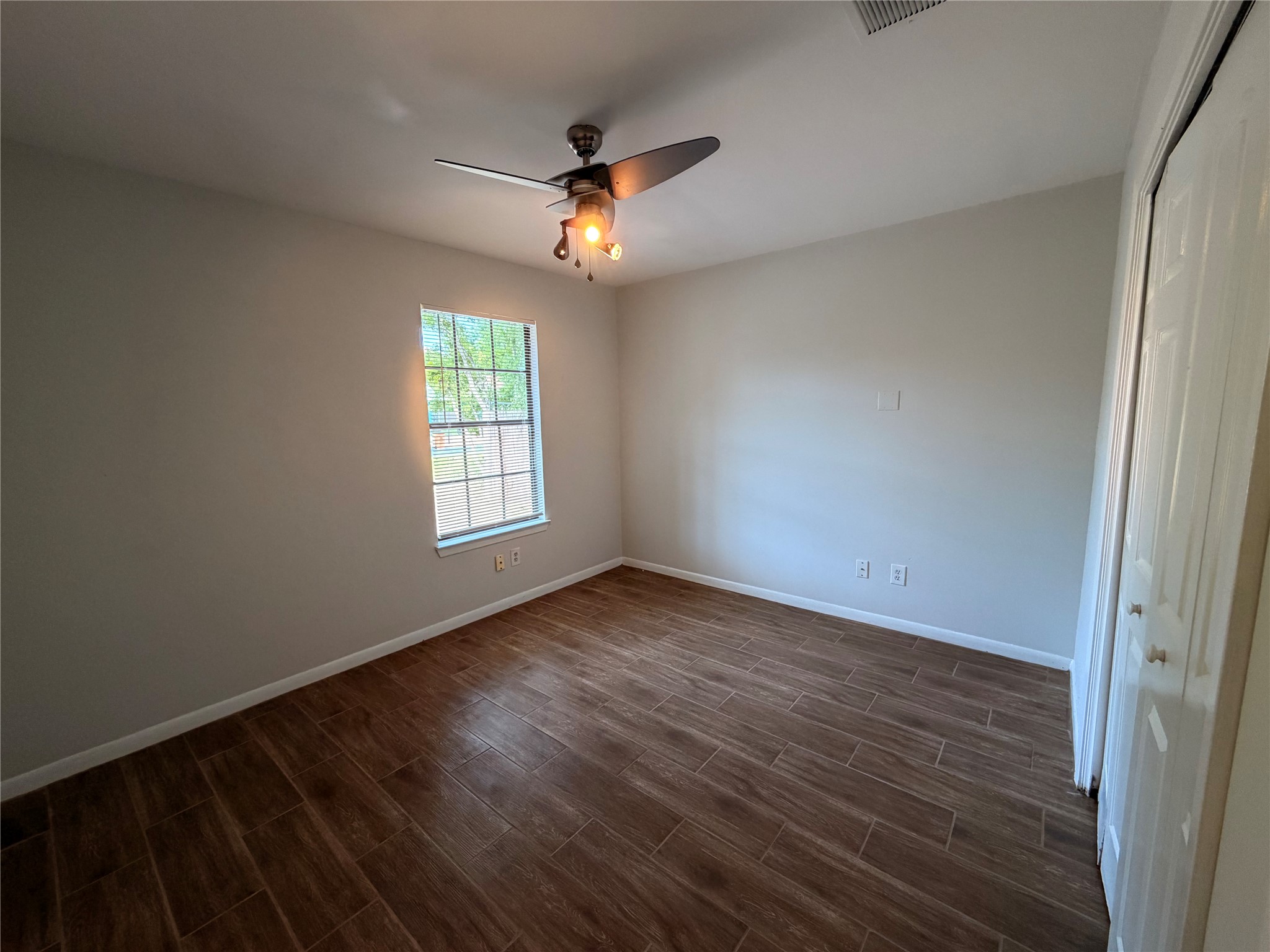 604 Gaylor Street, Unit A Austin, TX 78752 - Photo 5 of 5 Well-lit sleeping quarters with a ceiling fan, window treatments, and rich wood-look flooring.