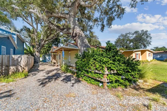 a view of yellow house with a large pool
