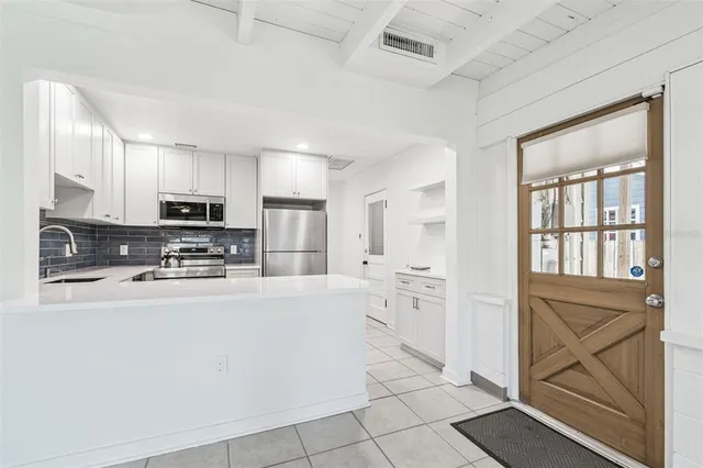 a kitchen with a refrigerator sink and cabinets