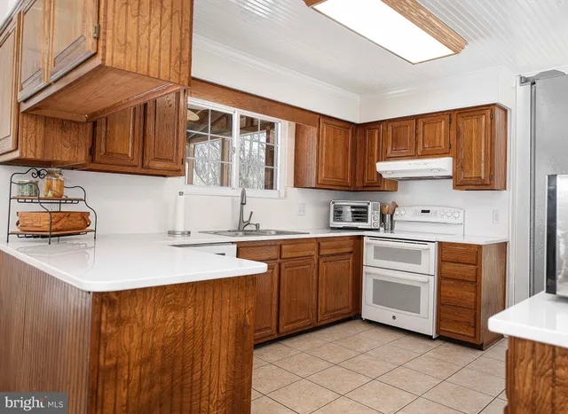 a kitchen with granite countertop a sink stainless steel appliances and cabinets