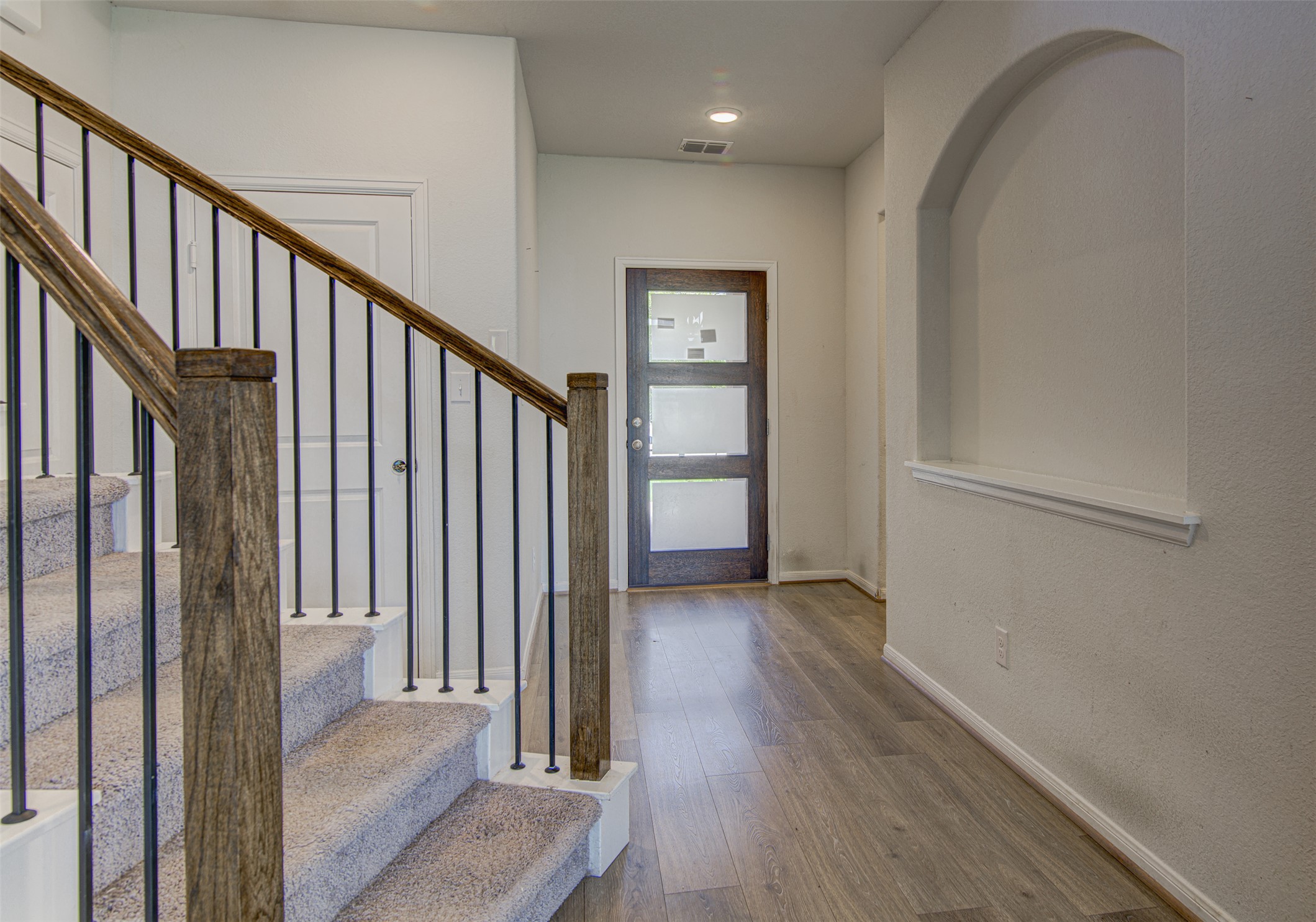 774 Cherrystone Loop Buda, TX 78610 - Photo 4 of 38 A striking entry hall with light wood flooring welcomes you, alongside a contemporary door with frosted glass panels.