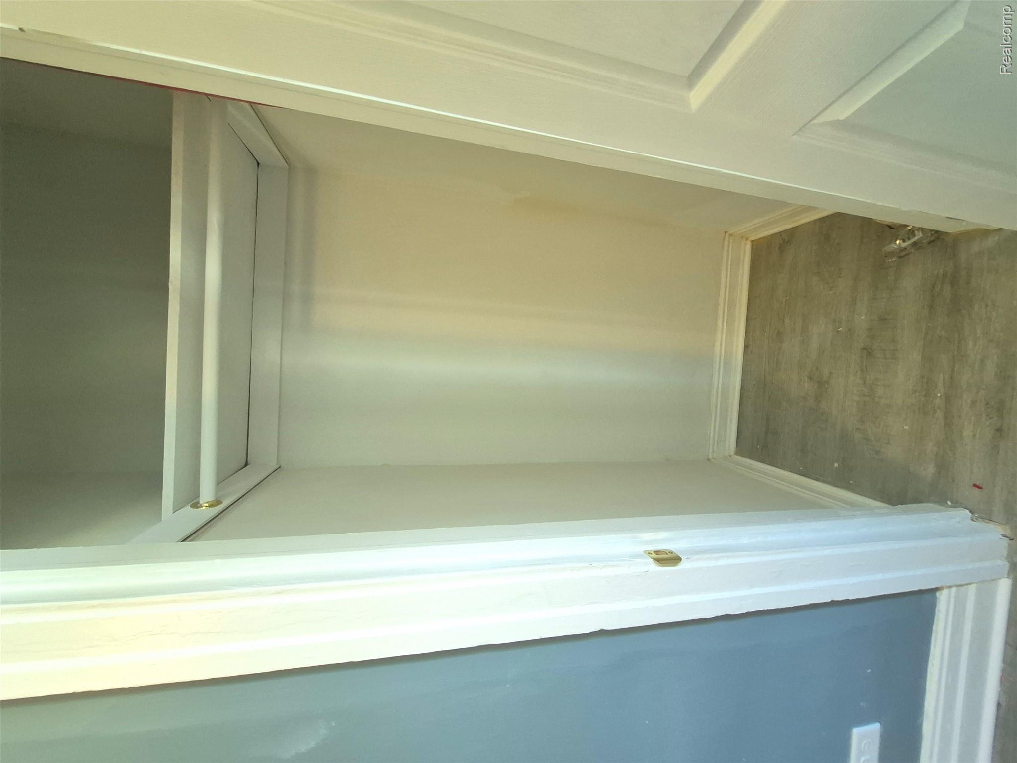 16758 Frazho Road Roseville, MI 48066 - Photo 22 of 53 Built-in shelving with a hanging rod, light-toned walls, and wood-finish flooring