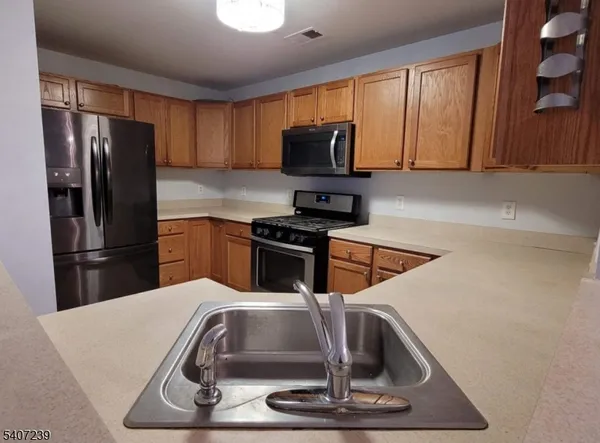 a kitchen with kitchen island a large counter appliances a sink and cabinets