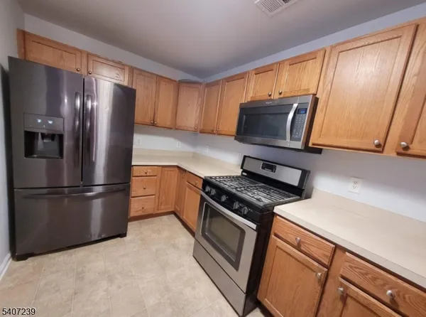 a kitchen with stainless steel appliances granite countertop a refrigerator stove and microwave
