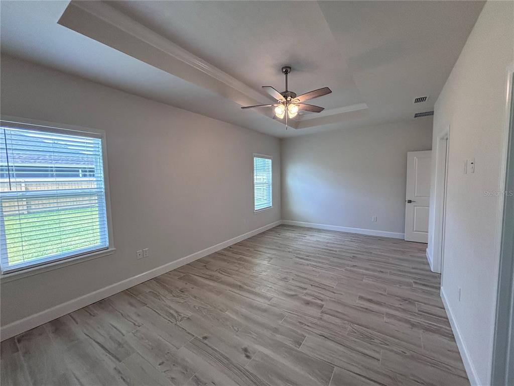 6686 Southwest 11th Lane Gainesville, FL 32607 - Photo 5 of 24 an empty room with wooden floor chandelier fan and windows