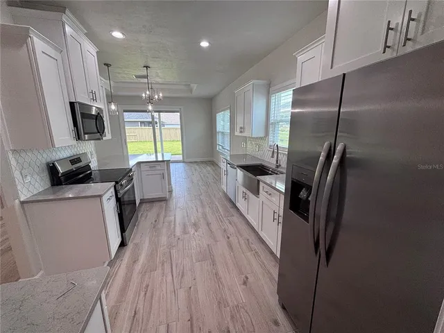 a kitchen with stainless steel appliances a refrigerator and a stove top oven