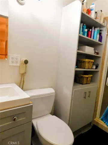 a white toilet sitting next to a bathroom sink and vanity