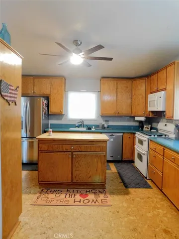 a large kitchen with stainless steel appliances granite countertop a sink a stove a refrigerator and island