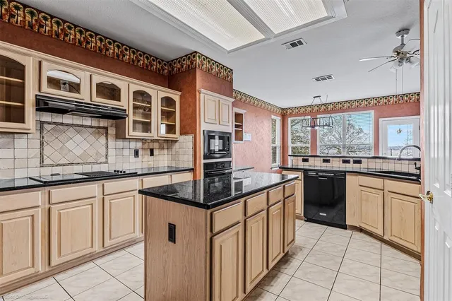 a kitchen with stainless steel appliances granite countertop a sink and cabinets