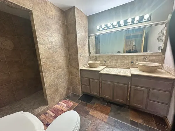 a bathroom with a double vanity sink mirror and toilet