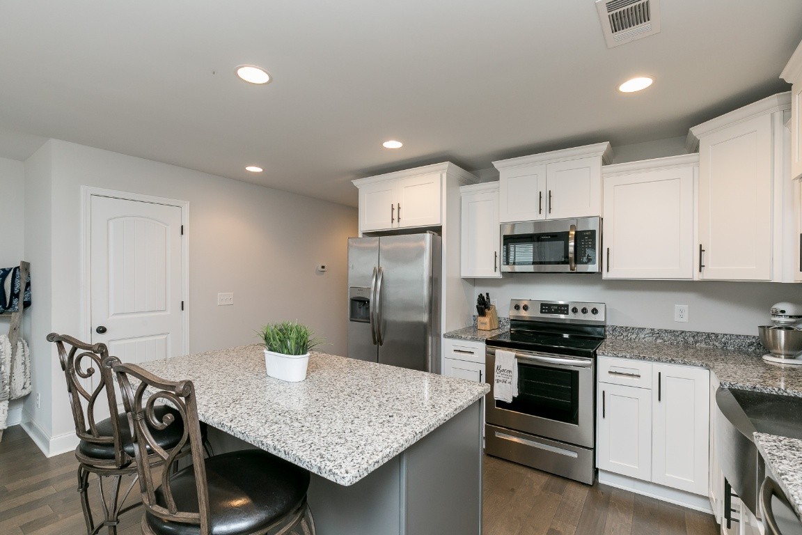 272 Signature Place Lebanon, TN 37087 - Photo 11 of 36 a kitchen with stainless steel appliances granite countertop a stove refrigerator and a microwave